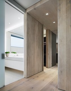 The flooring is comprised of wide-plank Danish oak from Dinesen, which is also featured in select wall panels and used to create the thick, full-height doors to the master bedroom.
