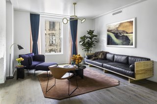 A large custom-made leather sofa from Wherewithal defines the living room, making it a comfortable space for entertaining. The Cloud One Seater lounge chair by Luca Nichetto and a Bellevue Floor Lamp by Arne Jacobsen form a perfect reading spot near the window, offering views of Brooklyn's neighboring brownstones. 