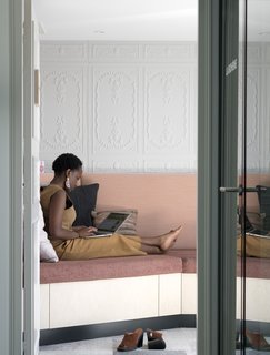 The "espace zen" is a peaceful space created for employees to have a peaceful area for quiet reflection or a quick nap. The space features a built-in sofa with plush pillows and a private balcony. 