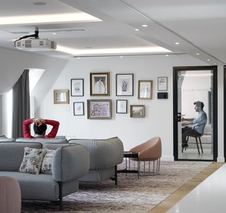 Inspired by local landmark Opera Garnier, the custom carpet in the hospitality lounge includes traditional patterns often found within Opera Houses. This traditional design element is juxtaposed with contemporary furniture and a gallery wall of artwork that references Airbnb, travel, and the opera.
