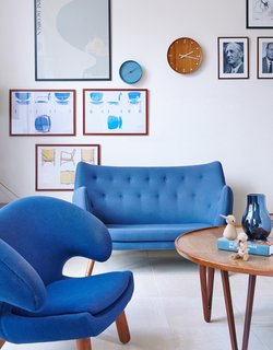 The mood is set with a Poet sofa and Pelican chair by Finn Juhl, vintage prints, and a coffee table from Tove and Edvard Kindt-Larsen. 