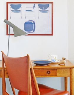 Finn Juhl's Egyptian chair is paired with a Lady Writing Table by Hans J. Wegner. The desk lamp is by Arne Jacobsen.