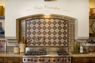 Hand-painted tiles make for a charming backsplash. The kitchen was designed in collaboration with Fleetwood Joiner and & Associates to closely match the style of the home. 