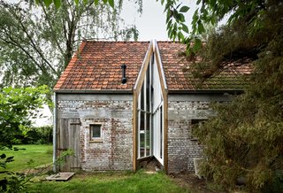 A New Book Examines the Art of Breathing Life Into Forgotten Architecture - Photo 12 of 16 - For this old farm building in the back garden of a larger set of farm buildings in Flanders, Belgium, Architecten de Vylder Vinck Taillieu converted an original brick structure into a modern home for the family's grown daughters. The simple incision of glass-and-mirrors brings light into the space, and successfully divides the interior into separate rooms. 