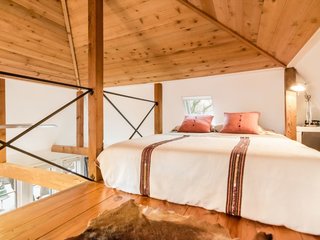 Feel at Home While Exploring Austin at One of These Modern Short-Term Rentals - Photo 16 of 17 - It's an open space with a cathedral ceiling and exposed-cedar beams. There's a queen-sized bed on the main level and another in the loft area.
