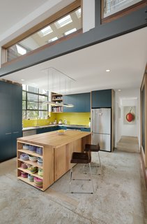The open kitchen features custom cabinetry and a recycled timber island. 