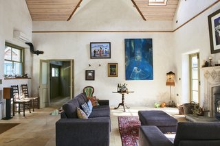 The original structure includes a living room that features high ceilings with beautiful wood panels and angled skylights. It sits adjacent to a kitchen with a breakfast room on one side, and a formal dining area on the other, which can also be used as a library.