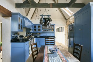 The kitchen is located in the old stone gasworks and features a vaulted ceiling and bespoke, painted cabinets.