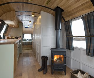 Live the Airstream Life Vicariously With a New Book That Celebrates the Timeless Trailers - Photo 10 of 19 - Called the English country retreat, this renovated interior that was done by ARC Airstreams features quality furnishings and fttings, Leadlight windows, and a fully functional fireplace.