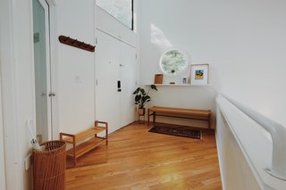 The three-level home's lofty entrance opens from the ground level, which looks out over the airy living room. 