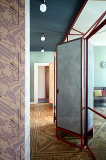 An initial partition creates a relationship between the entrance and living room, preserving the original design of the parquet flooring with inlaid "squares." 