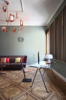 The living area includes a Lars sofa by Bonaldo, a Leaf chandelier by MM Lampadari, a Frate dining table/desk by Enzo Mari for Driade, and a table lamp by Ettore Sottsass for Vistosi.