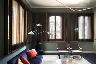 This living space is finished with a Lake Carpet by Raw Edges for Golran, Digamma armchairs by Ignazio Gardella for Santa & Cole, Shimmer coffee tables by Patricia Urquiola for Glas Italia, and an iconic floor lamp from Serge Mouille. 