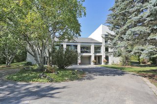 The discretely designed three-car garage centers the property and opens to a 360-degree circular driveway. A bright and airy living/music area with 22' ceiling is located above the garage.