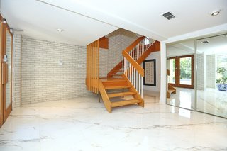 The entrance features marble floors and a grand staircase. The home was built with sturdy 2x6 construction and features plastered walls throughout.