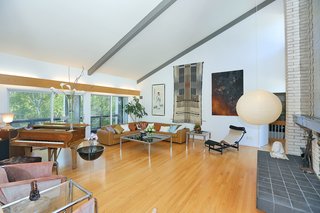 The living room is located on the ground floor and opens to an enclosed veranda which overlooks the front and the expansive verdant property.