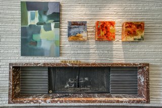 The living area also features a distinct low-profile mid-century modern fireplace. Sandstone elements which have been employed on the exterior of the home are carried through to the interiors. 