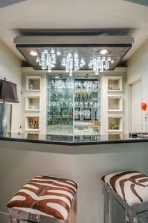 A bar area showcases custom-made cast lighting and built-in cabinetry.