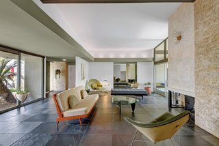 The interiors fully embrace the midcentury aesthetic with high-beamed ceilings, slate floors, custom wood flooring, and a split rock fireplace. Expansive floor-to-ceiling windows frame stunning views of Mt. Eisenhower to the south.<br> <span style="color: rgb(204, 204, 204); font-size: 13px;">The Agency</span>