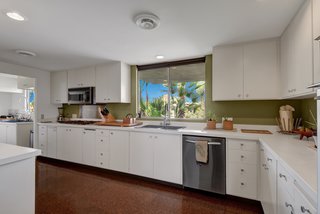The kitchen and prep kitchen feature stainless-steel appliances, commercial fixtures, and cork floors. 