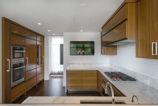 The customized open kitchen features top-of-the-line appliances. 