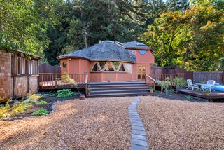 The property features not only the geodesic dome home, but also a large yard and two additional structures.