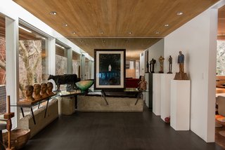 Classic midcentury touches such as floor-to-ceiling windows and a material palette of wood, glass, and stone characterize the 1951 residence. 