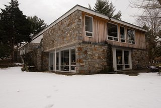 The boxy exterior is clad in a mix of stone and wood.