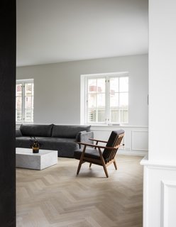 Dark midcentury teak furniture and classic marble are set against a white backdrop. 