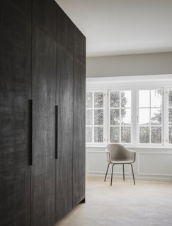 A large kitchen cabinet covered in dark stained oak separates the kitchen from the living room. 