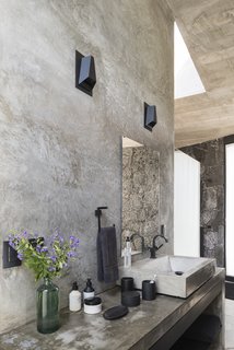 The raw materiality of the interiors is reflected in one of the bathrooms. 