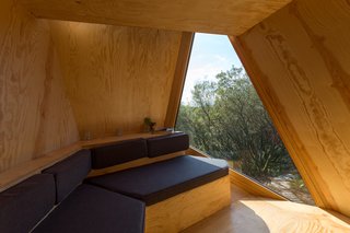 Go Off The Grid With These Remote Rental Cabins in Cornwall - Photo 9 of 12 - The petite interiors have a built-in sofa, along with floor-to-ceiling windows.