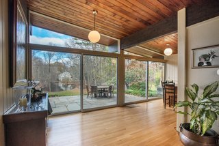 Own an Iconic Midcentury in New Canaan For $1.55M - Photo 6 of 12 - Floor-to-ceiling walls of glass allow for expansive views of the property and pond. 
