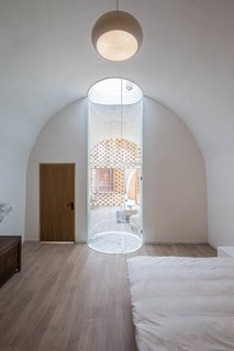 A circular glass light was implemented in the middle of the cave to form a large transparent tunnel, which now naturally illuminates the interior.