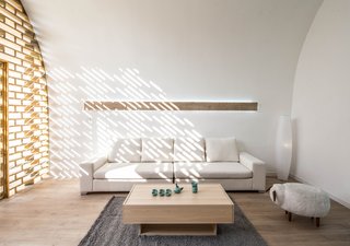 The large timber screen allows natural light to enter—as well as playful decorative shadows—while still maintaining a sense of privacy from the outer courtyards.