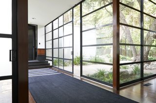 A steel-and-glass wall of windows surrounds the interior courtyard. 