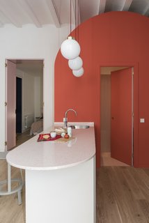 The rounded island houses a sink and dishwasher, and also doubles as an informal eating area. 