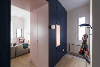 A cut-out pink doorway connects the living area to the entrance, while hiding the closet doors on both sides. 