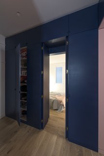 The lacquered panels of the bespoke storage unit conceal direct access to the bedroom from the main entrance through a double door.