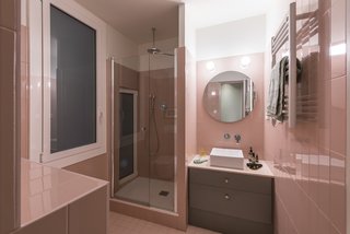 The guest bathroom picks up on the pink lacquered that runs throughout the apartment. 
