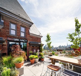 Guests can also dine al fresco on the terrace at wooden tables. The "No Vacancy" sign alludes to the building's boarding-house past. 