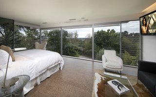 The master suite captures Neutra’s original vision with head-on views, a generous walk-in island closet, and a terrazzo bath with a sunken tub, steam shower, and dual vanity.