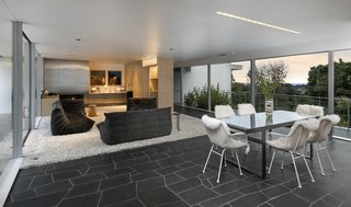Bertram retained Neutra’s open floor plan and minimalist aesthetic—soft white tones contrast with the dark slate geometric flooring.