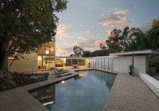 The kitchen and living room open to a large, geometric pool. 