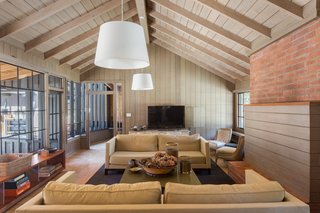 With original steel-framed windows, beamed ceilings, warm wood-paneled walls, and a gracious floor plan, this area makes for a wonderful entertaining space.
