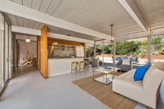 The interior of the home unfolds into an open kitchen/living area, creating multiple social spaces for entertaining.