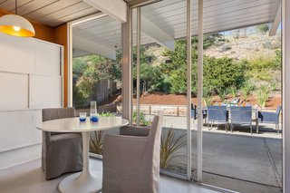 A small eating area overlooks the lush backyard. 