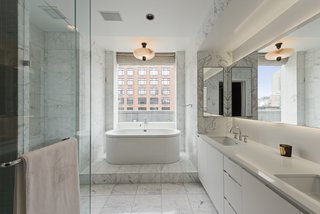The master bath features Statuary marble, heated floors, a Kaldewei Vaio Duo oval freestanding tub, a frameless glass-enclosed shower, Lefroy Brooks fixtures, and a Valcucine vanity.
