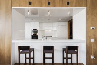 The Gwathmey Siegel–designed kitchen boasts Valcucine cabinetry of striated elm and smoked glass, Jet Mist granite, a Sub-Zero refrigerator, a Miele oven and dishwasher, a Gaggenau cooktop and fully vented hood, wine storage, and a cut-out breakfast bar that opens to the living room.