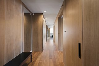 Wood-paneled walls concealing storage line the corridor and play off the unit's oak wood flooring. 